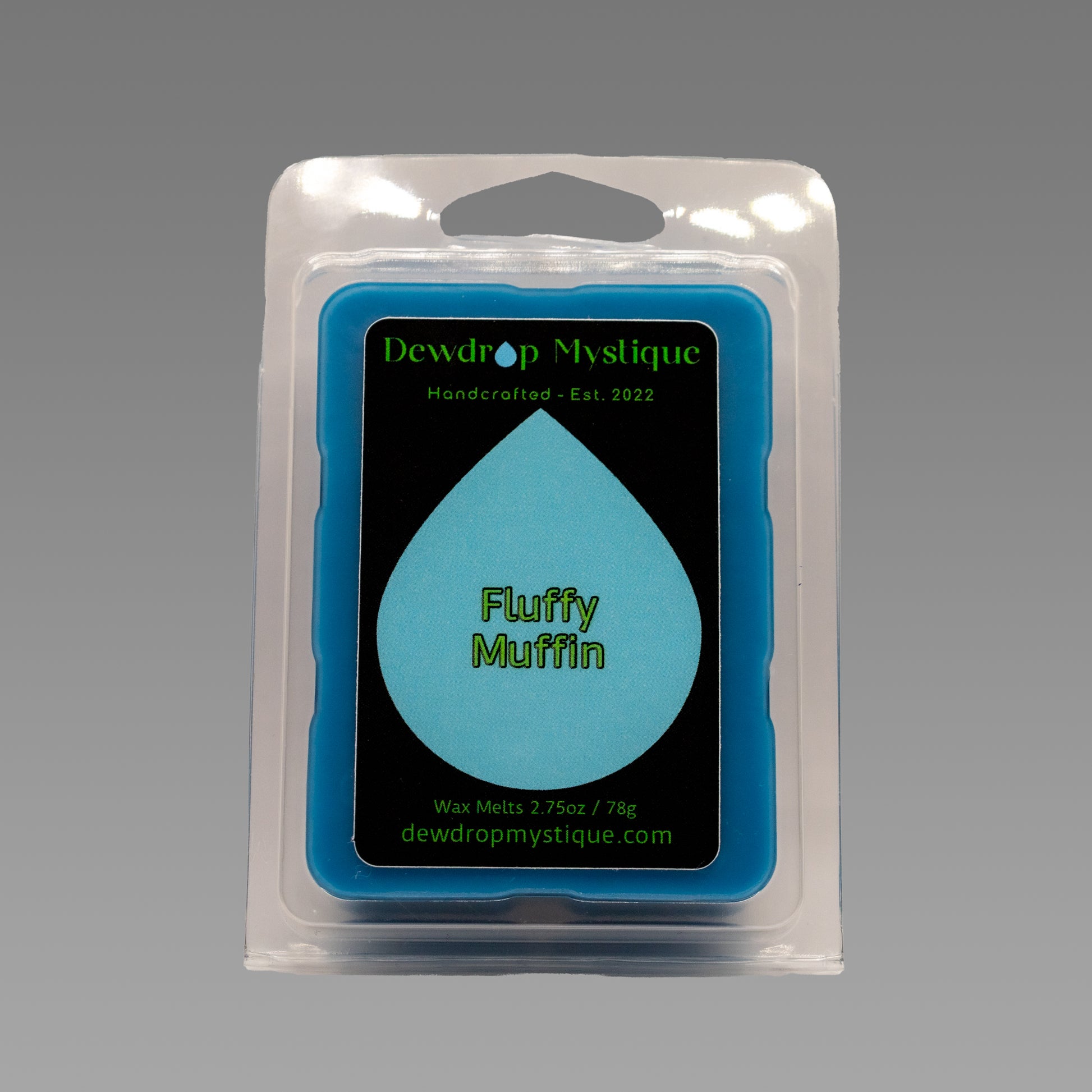A packaged wax melt in blue color, labeled 'Fluffy Muffin' from Dewdrop Mystique, with a graphic of a blue dewdrop on the front.
