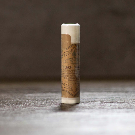 French vanilla lip balm tube on a wooden surface.
