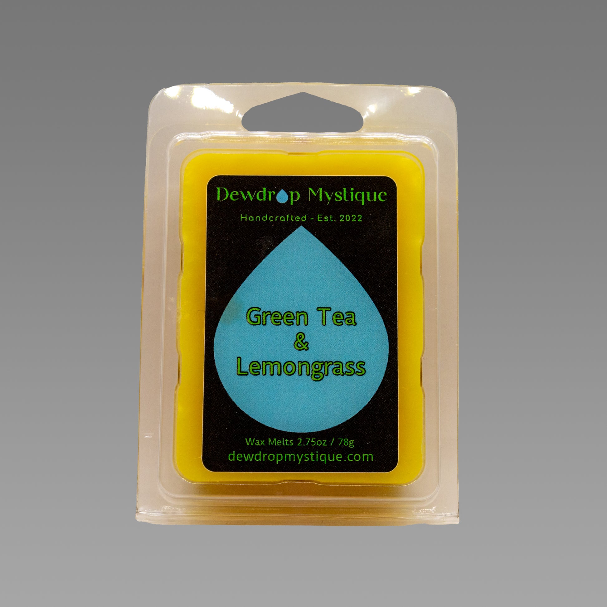 A wax melt pack labeled 'Green Tea & Lemongrass' from Dewdroup Mystique, established 2002.