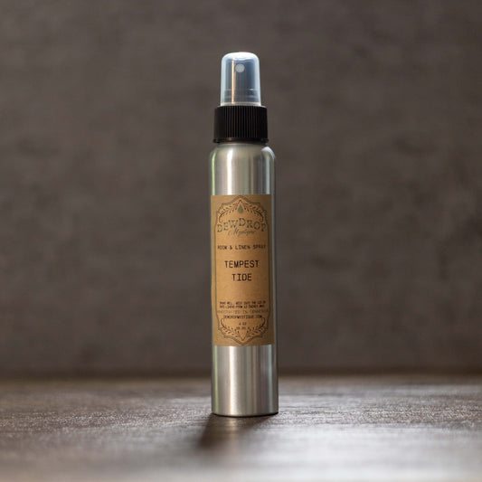 Metal spray bottle with a brown label on a wooden surface