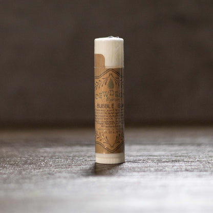 Bubblegum lip balm tube on a wooden surface.