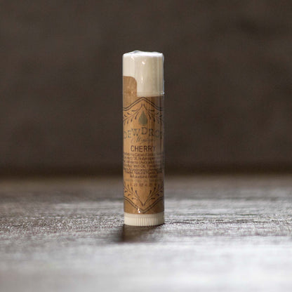 Lip balm stick with brown packaging on a wooden surface