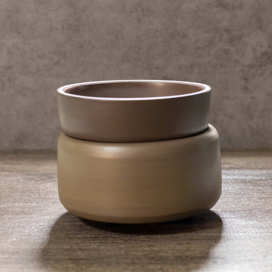 Two-tiered ceramic pot on a wooden surface with a neutral background